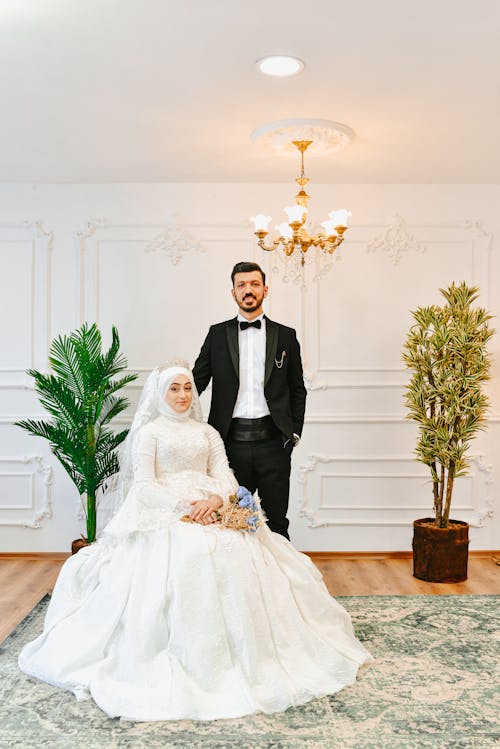 Photo of a Bride Sitting Beside Her Groom in a Suit