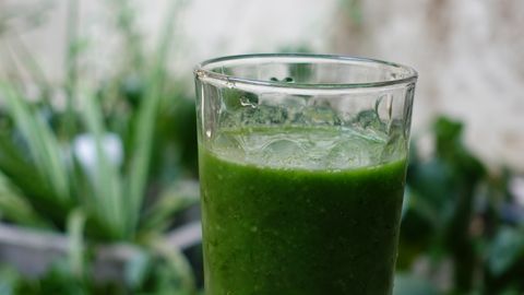 Vibrant green vegetable smoothie in a clear glass, ideal for a healthy, refreshing drink.