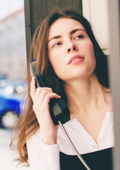 Portrait of a Woman Holding a Black Telephone