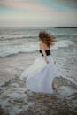 一名身穿白色连衣裙的女子在海滩上自由起舞，拥抱海浪