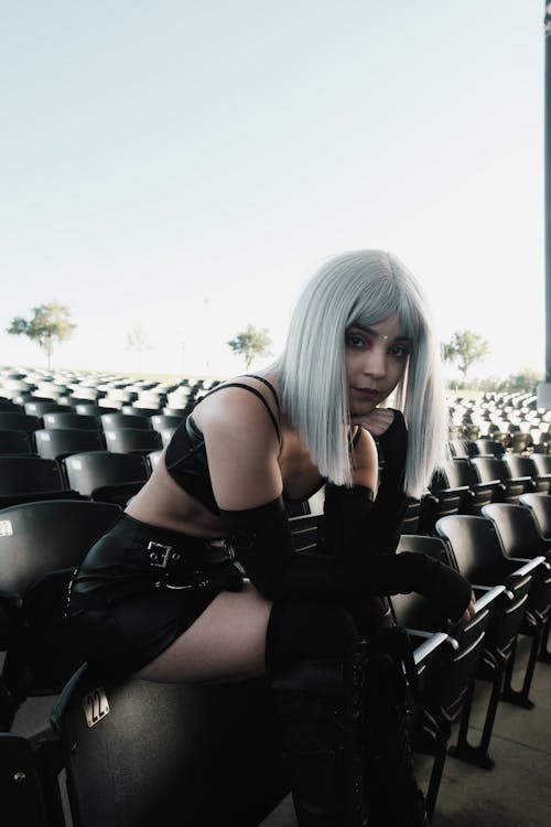 Photo of a Woman with Silver Hair Sitting on Bleacher Chairs
