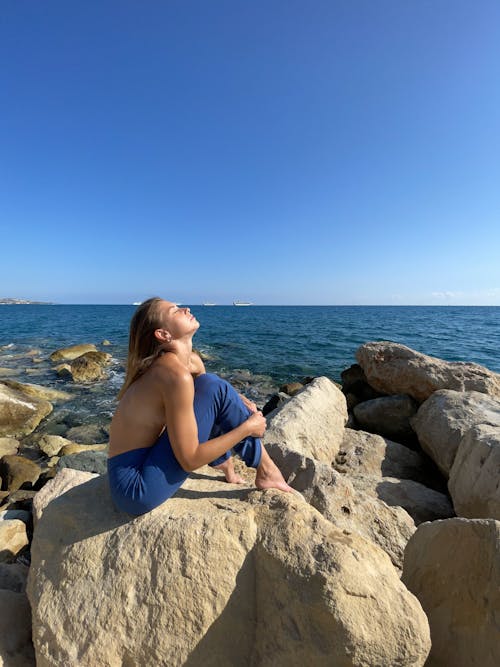 A Woman Sitting on Brown Rock