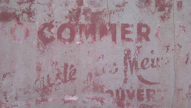 Aged concrete wall with faded red typography, perfect for grunge backgrounds.