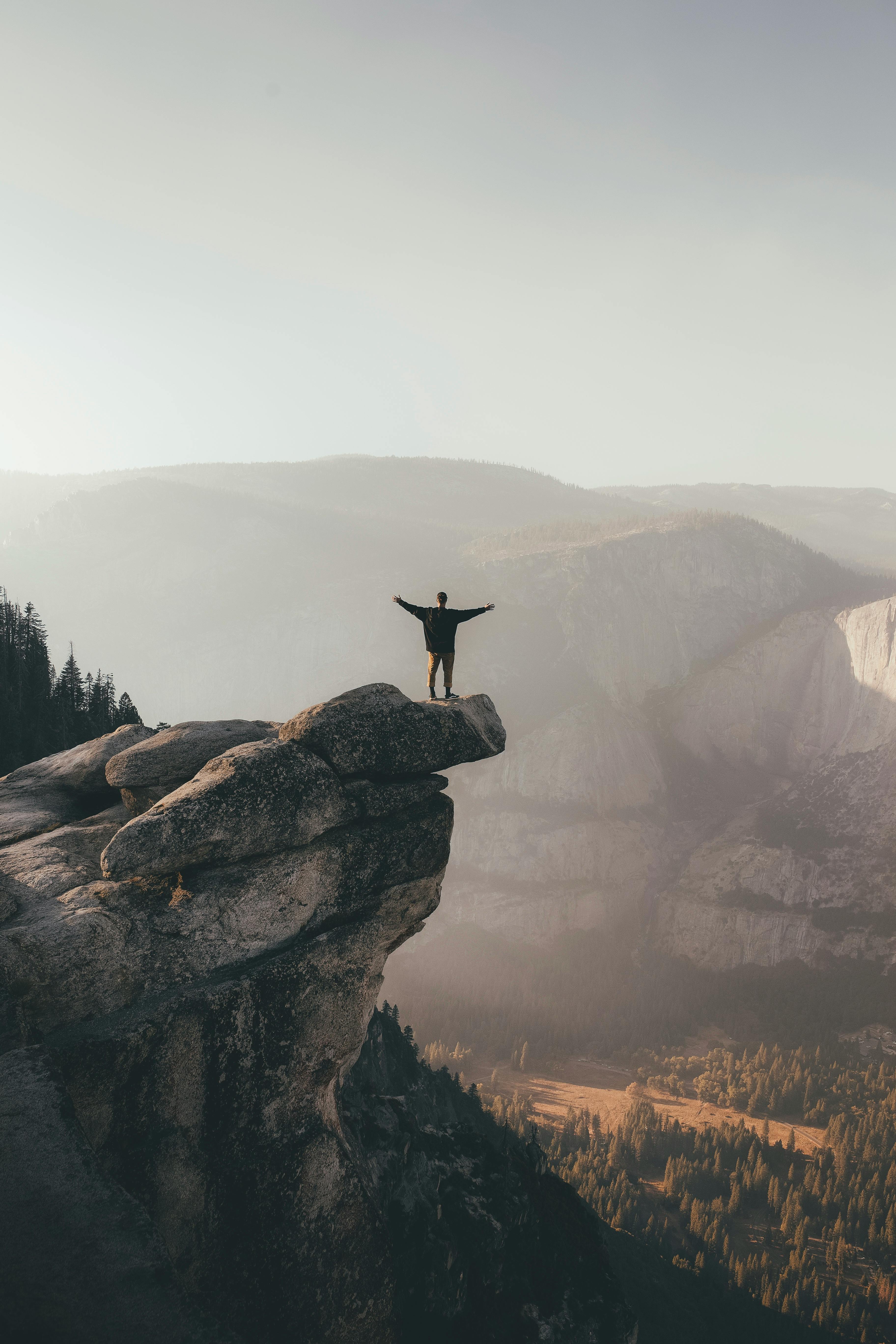 Person Standing on the Edge of a Rock Formation · Free Stock Photo