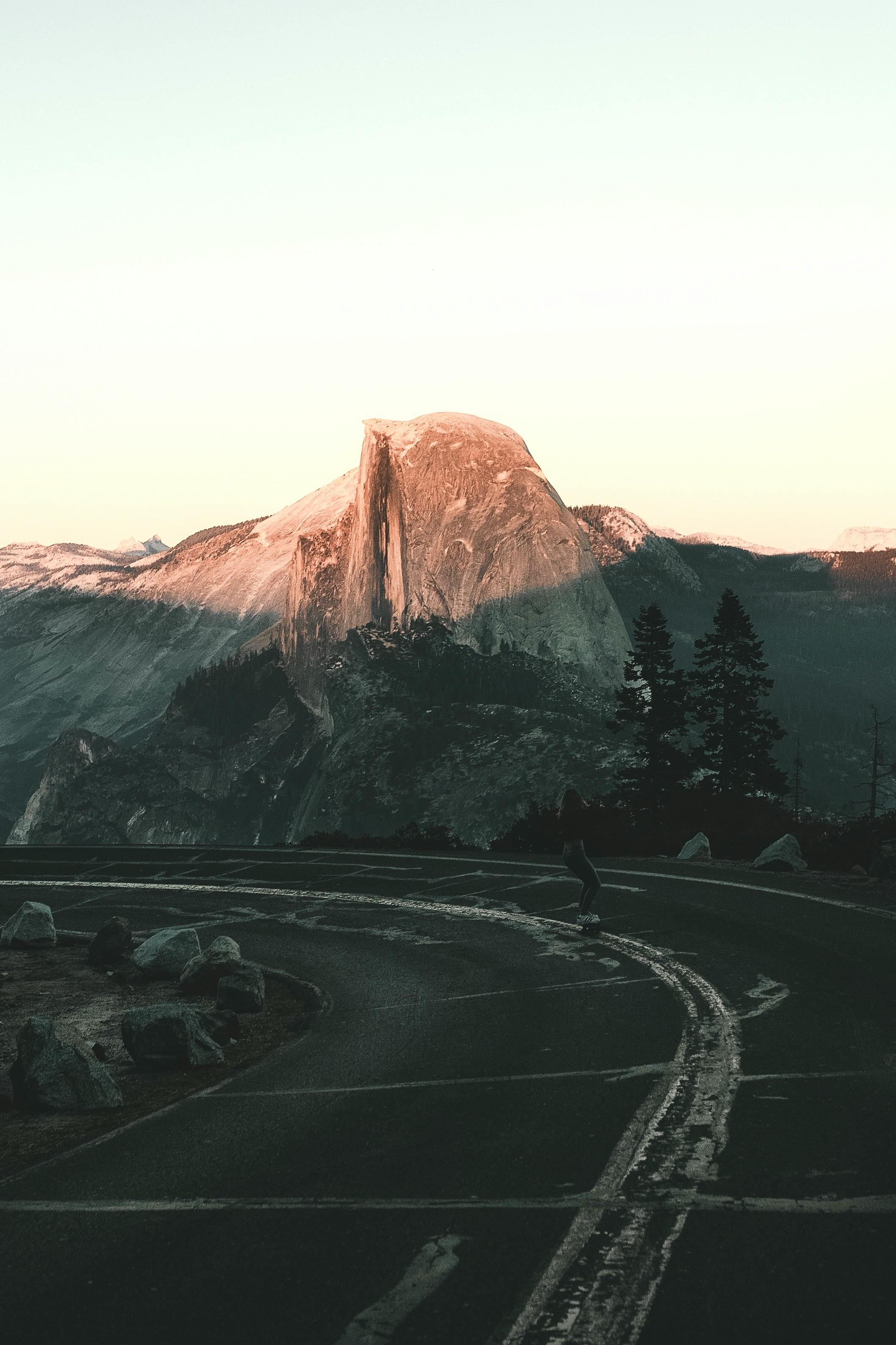 Capturing the serene sunset over Half Dome at Yosemite with winding road.