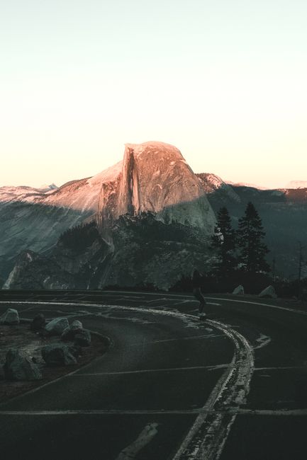 Capturing the serene sunset over Half Dome at Yosemite with winding road.