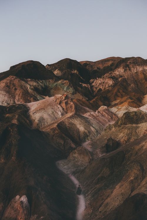 Free A breathtaking view of a multi-colored mountain range with a winding path at dusk. Stock Photo