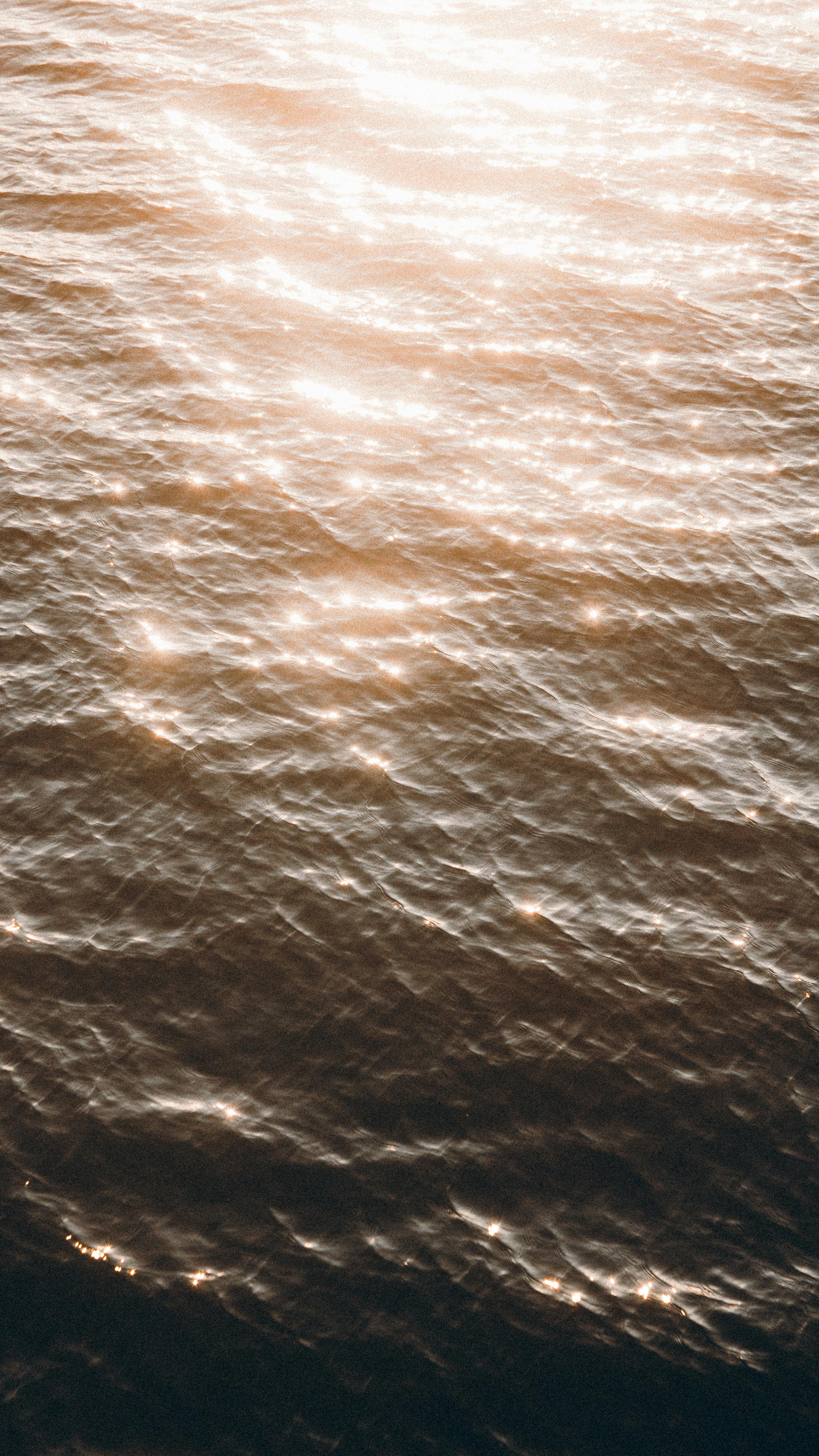 Captivating golden sunlight sparkling on water waves in Ternopil, Ukraine.