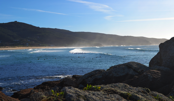 Captivating view of coastal waves meeting rocky shores under a clear sky.