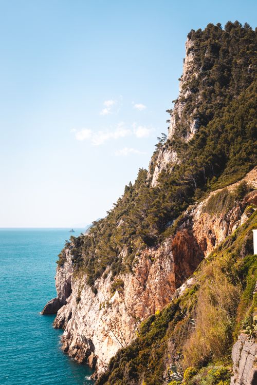 Free Beautiful cliffside overlooking the sea in Liguria, Italy under a clear sky. Stock Photo