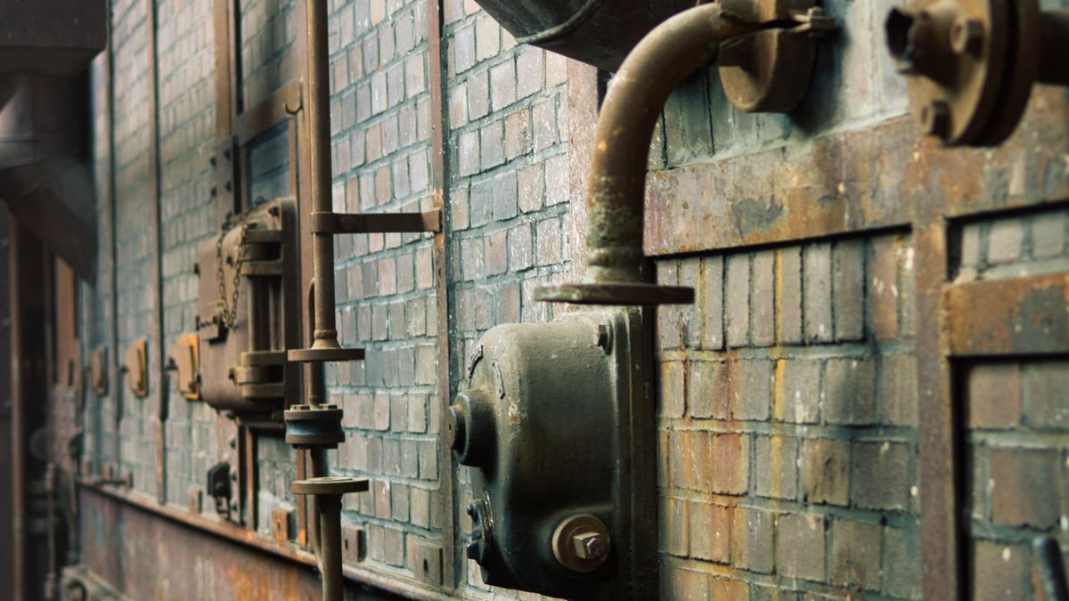 Old metal pipes in a factory representing the lead pipe replacement deadline for drinking water systems