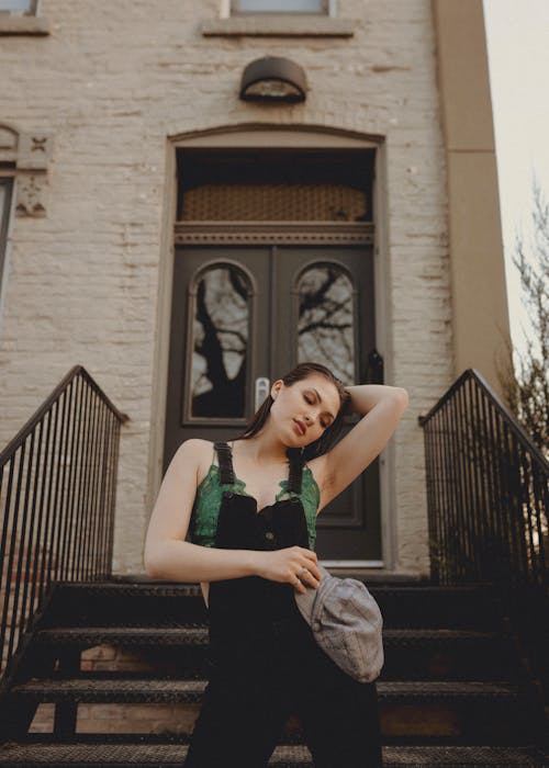 Woman Standing on the Stairs Outside a Building