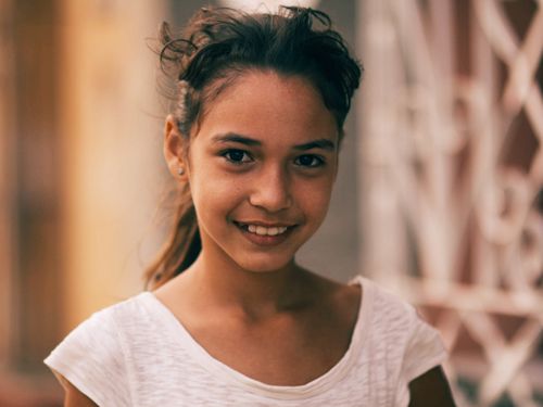 Free Close-up portrait of a smiling girl outdoors with a blurred background. Stock Photo