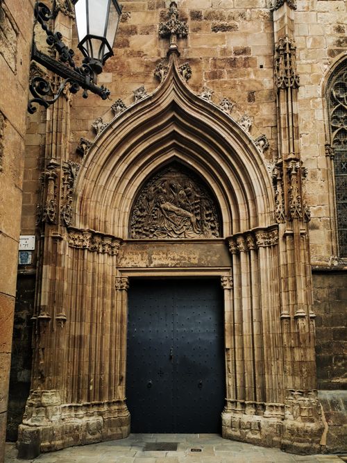 Free Intricate gothic doorway with detailed carvings on a historic cathedral in Barcelona. Stock Photo
