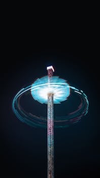 Bright, long exposure shot of a spinning theme park ride against a night sky.