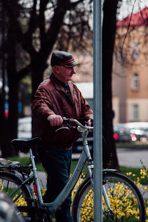 Free An Elderly Man Walking with His Bicycle Stock Photo
