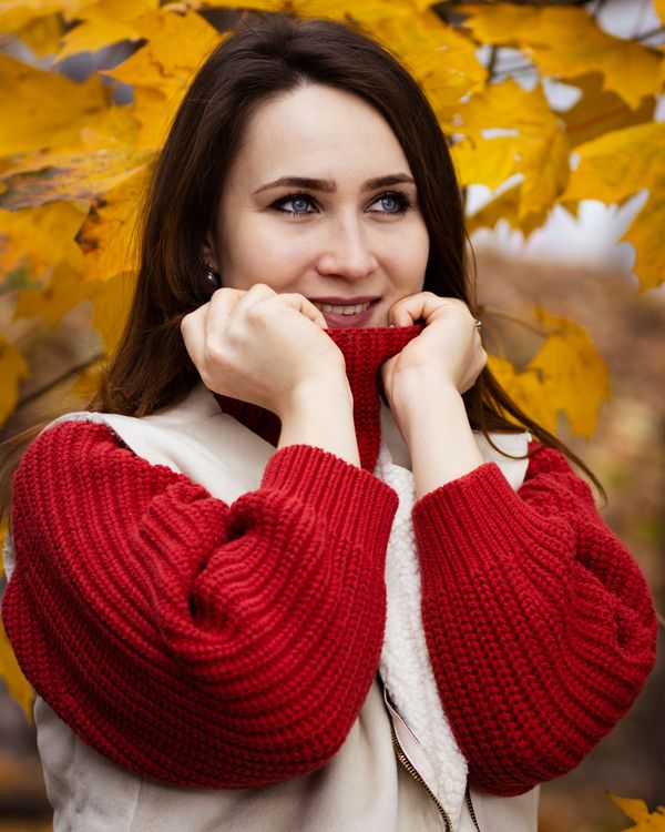 Woman in red sweater and beige coat