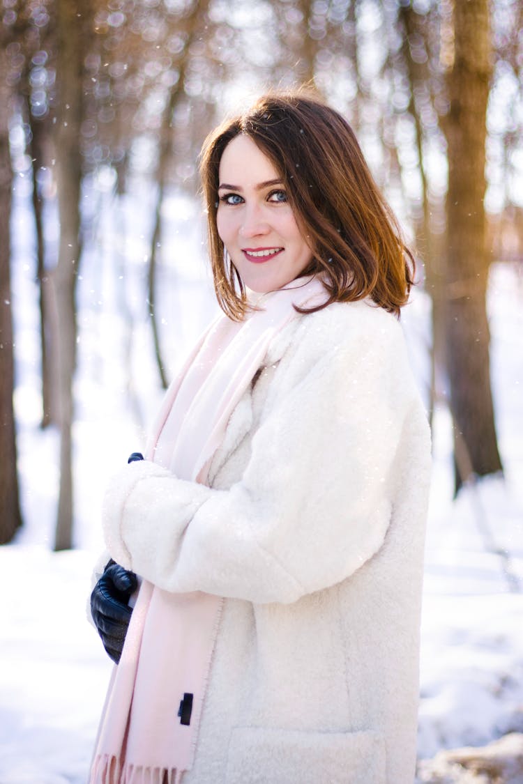 A Woman Wearing A White Wool Coat And Scarf