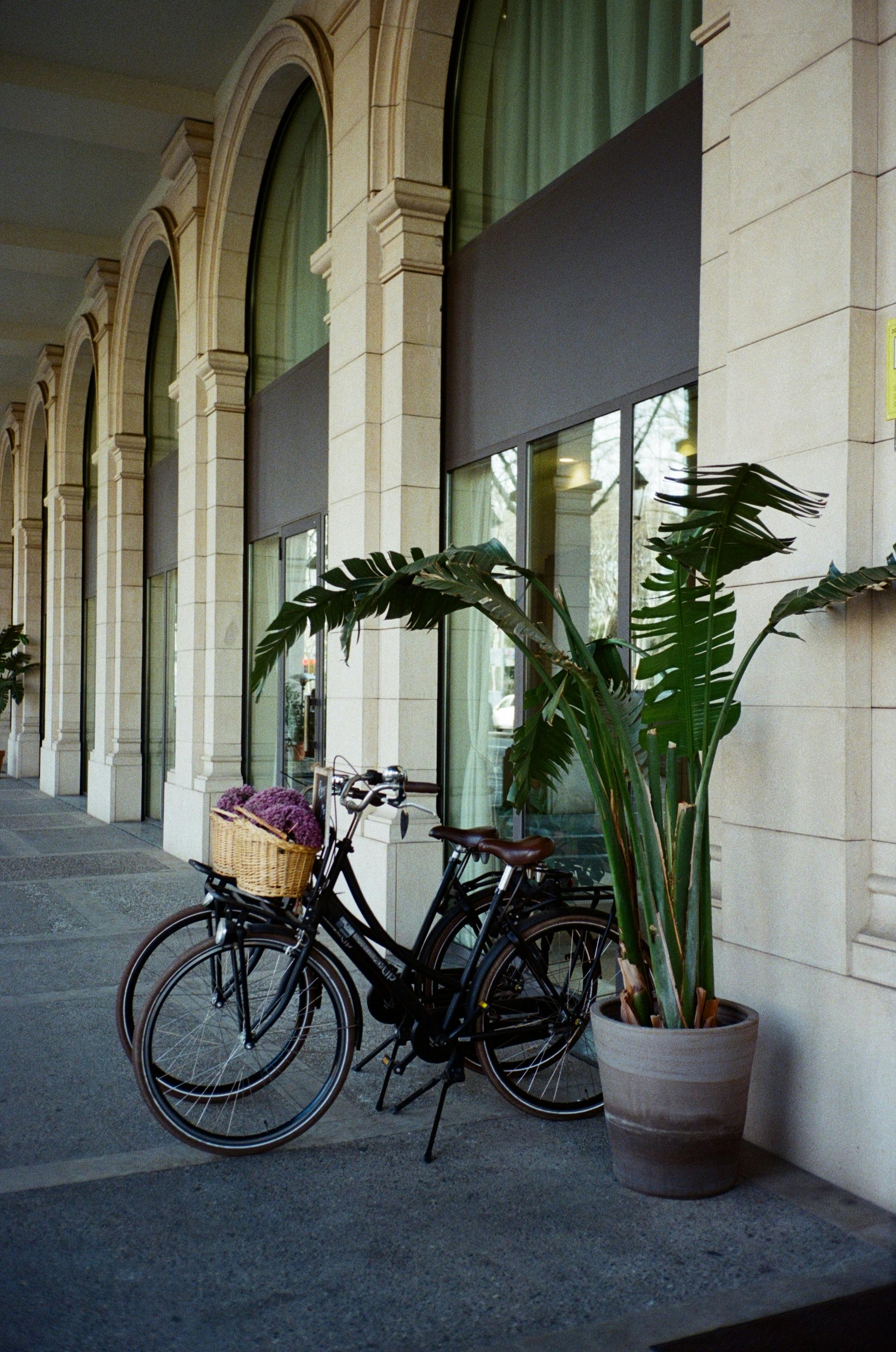Bicycle parked under elegant arches in urban Barcelona setting.