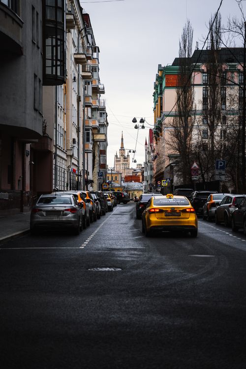 Free A bustling street in Moscow with parked cars and a view of Lomonosov Moscow State University tower. Stock Photo