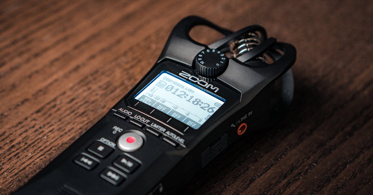 Detailed close-up of a digital audio recorder placed on a wooden surface, showcasing modern recording technology.