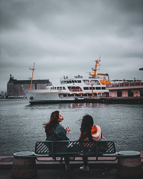 Photo of Women Sitting Near a Cruise Ship