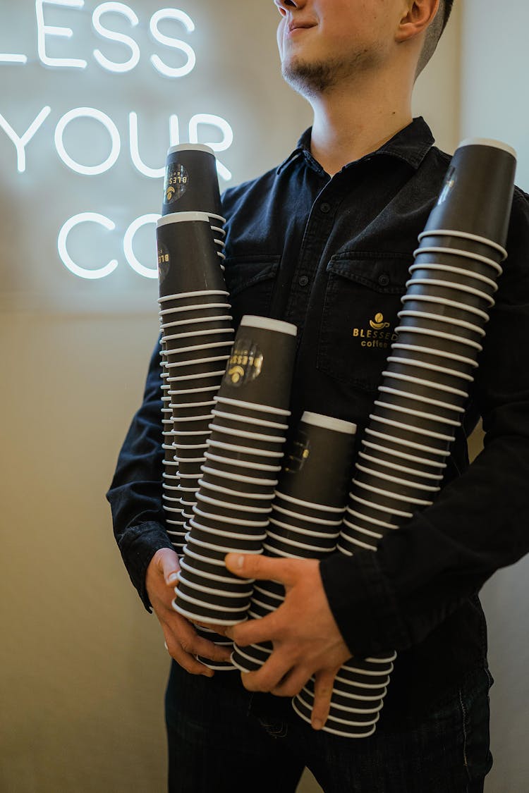 Man Carrying Stacks Of Coffee Cups