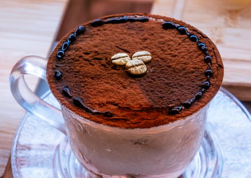 Free Close-up of a rich cappuccino sprinkled with cocoa and decorative elements, served indoors. Stock Photo