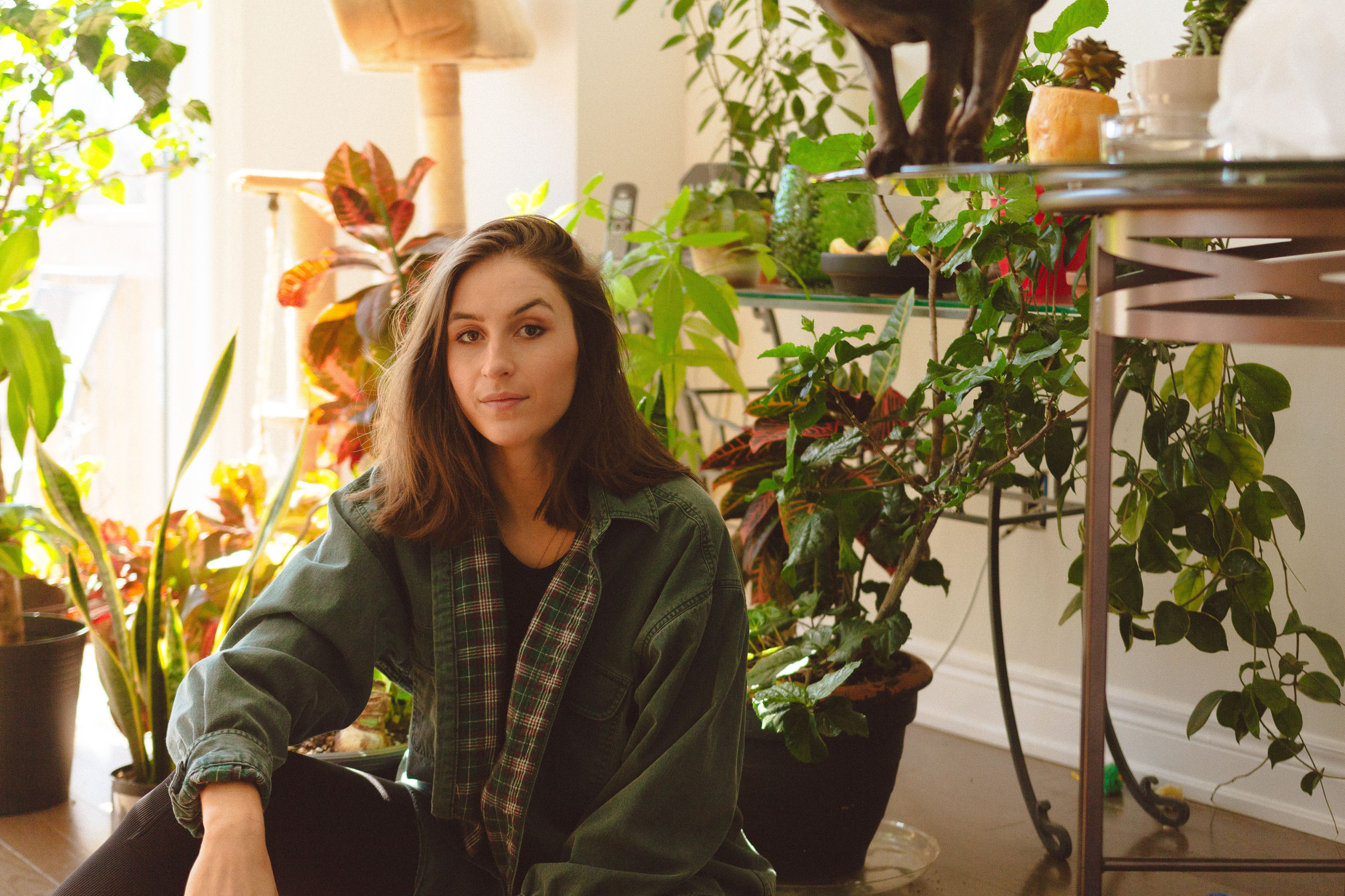 A Woman Wearing a Green Jacket Sitting on the Floor · Free Stock Photo