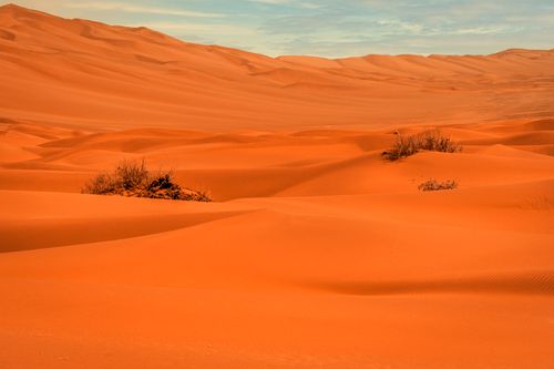 Free Beautiful orange sand dunes stretch across a vast desert landscape, showcasing nature's serene beauty. Stock Photo