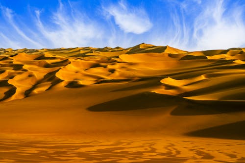 Desert under White Clouds and Blue Sky