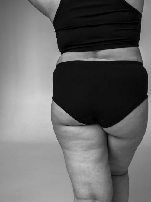 Free Black and white image showcasing body positivity with a focus on plus-size fashion in a studio setting. Stock Photo