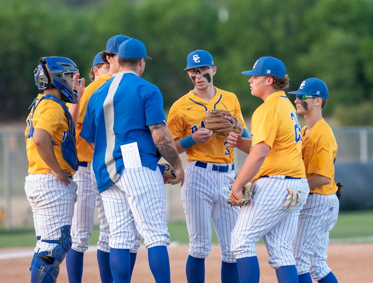 A Team Of Baseball Players Having A Conversation
