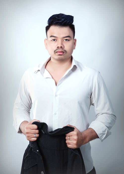Photo of a Man in a White Dress Shirt Holding a Jacket