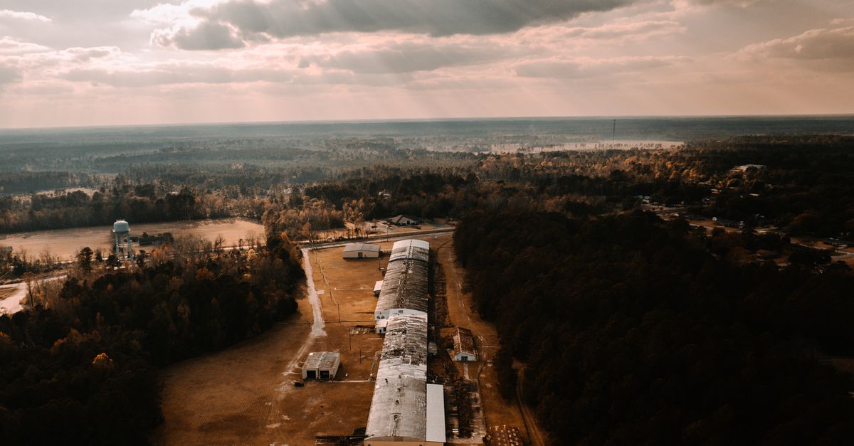 Drone shot capturing an industrial area in Varnville, SC, with dramatic sunlight filtering through clouds.
