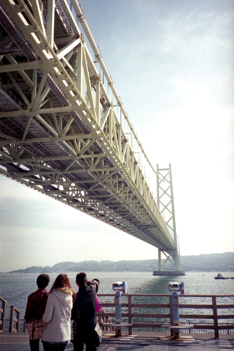 People Standing Under The Bridge