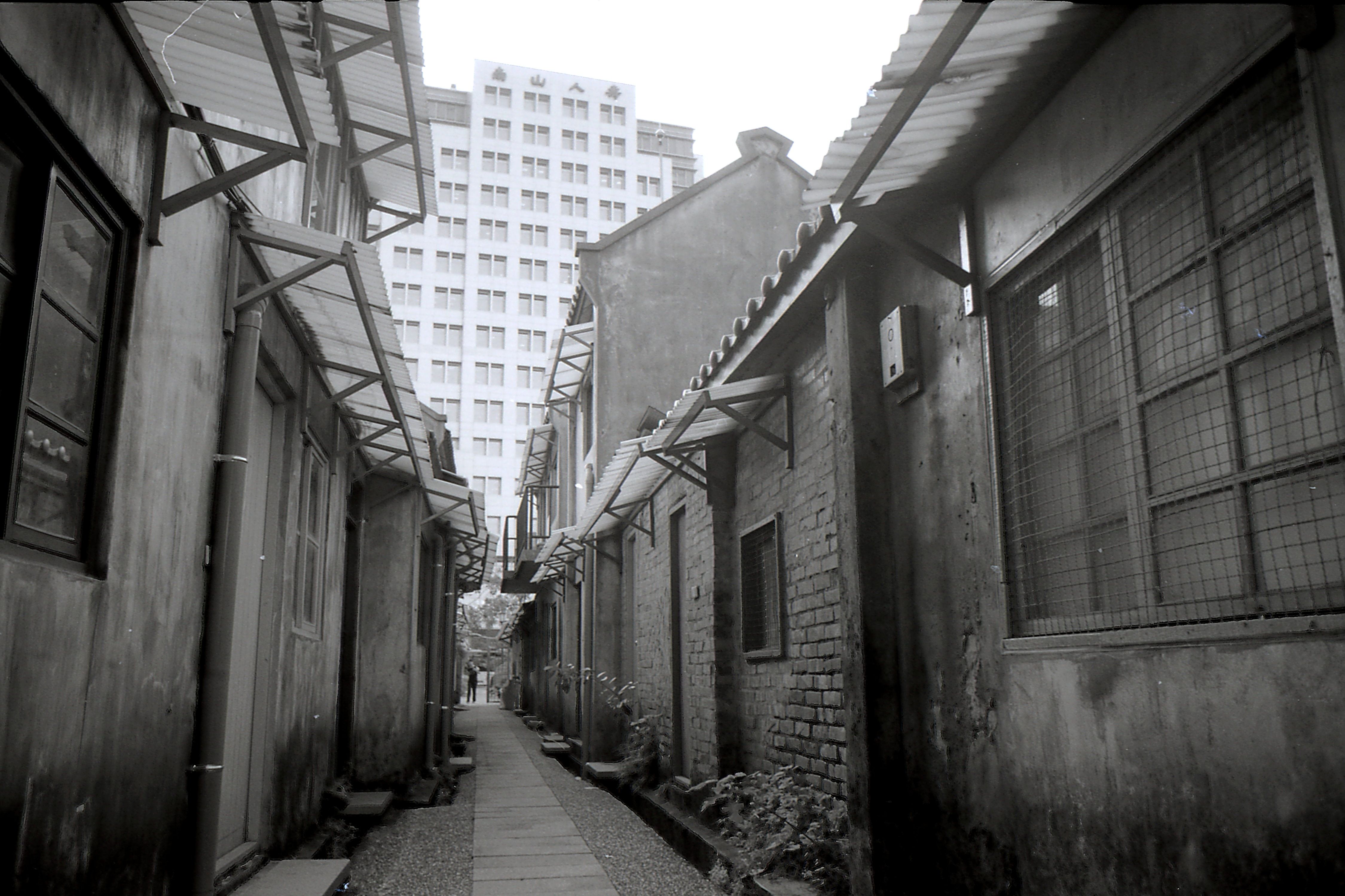 Narrow grayscale alleyway in Taipei City, Taiwan, with urban architecture