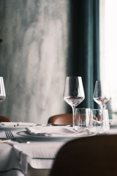 Sophisticated indoor restaurant table setting featuring wine glasses and cutlery.