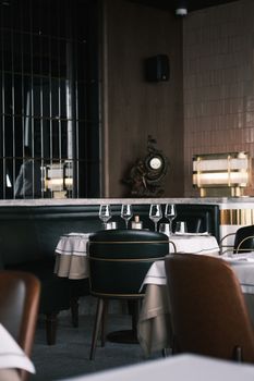 Cozy restaurant interior featuring classic round tables and sleek chairs with table settings.