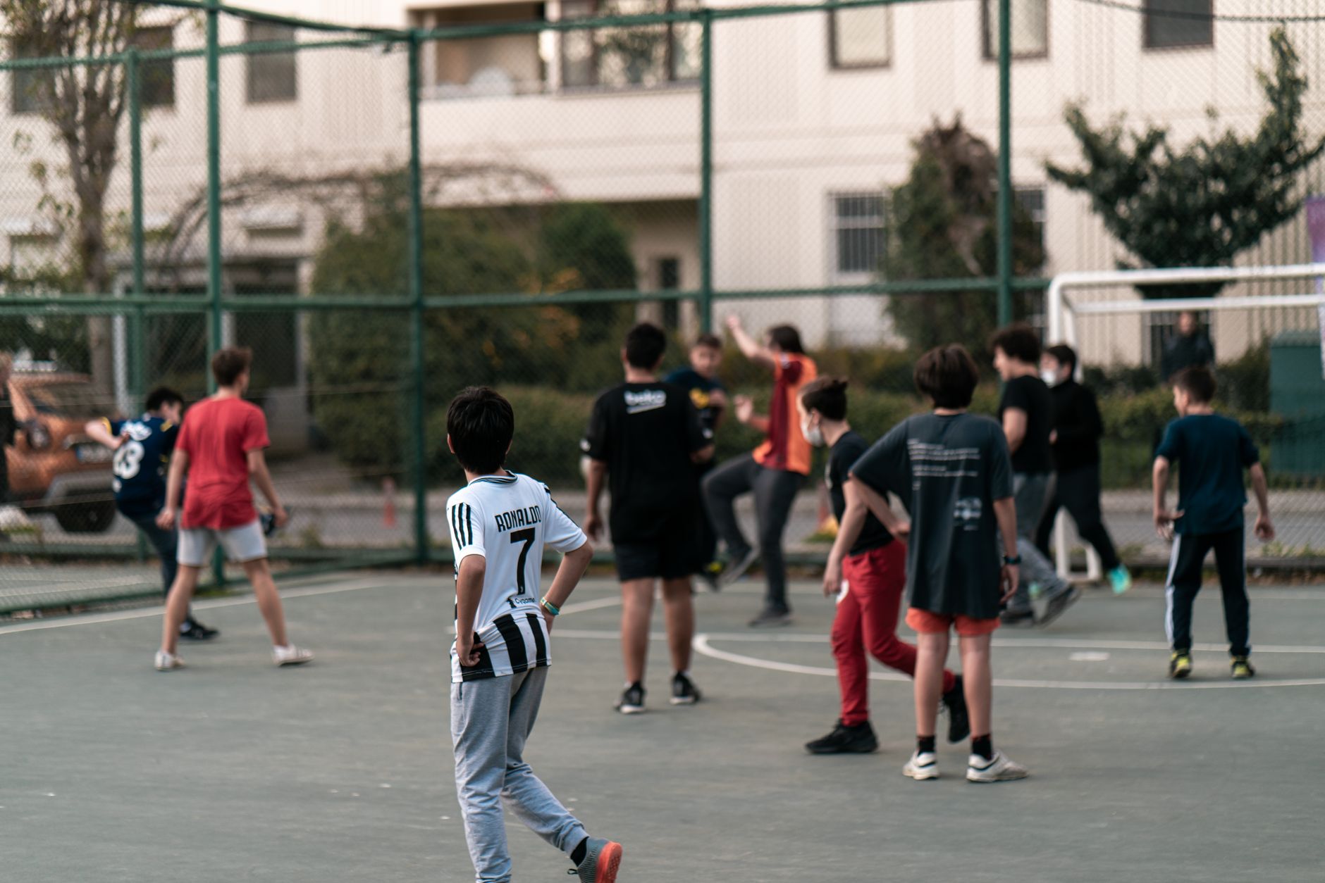 A group of teenagers playing football on an outdoor court in Istanbul, Turkey, showcasing active youth engagement.