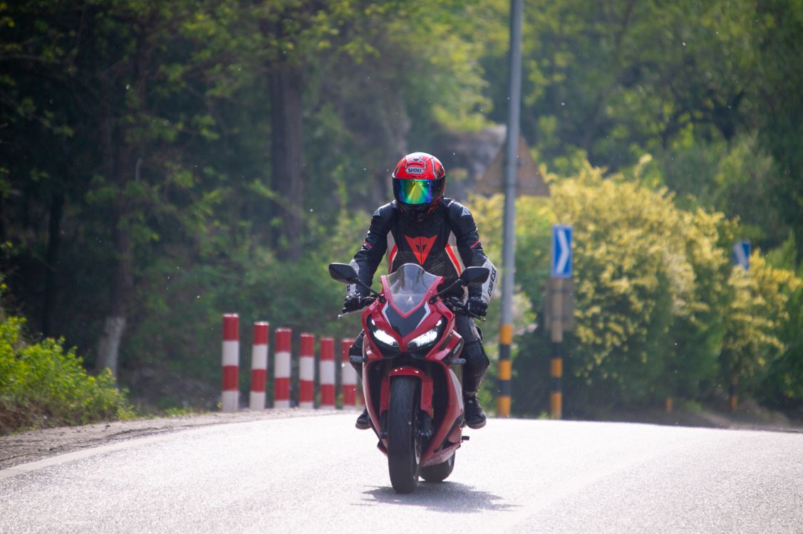 Photo of a Person with a Red Helmet Riding a Motorcycle · Free Stock Photo