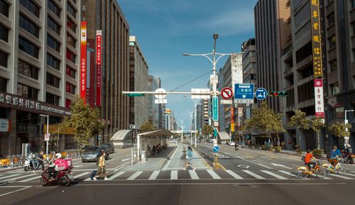 Free Bustling city street featuring pedestrians crossing and cyclists in an urban setting. Stock Photo
