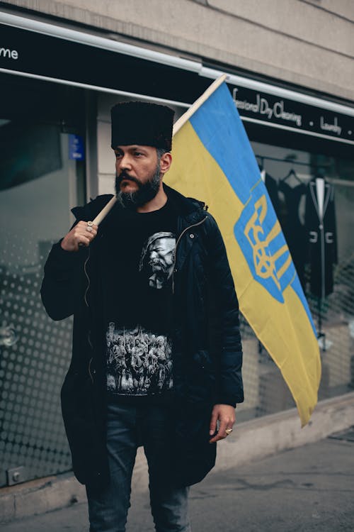 Man Carrying a Ukraine Flag on the Street
