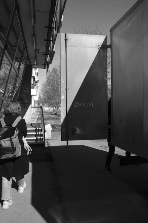 Monochrome Photo of a Woman with a Backpack Walking