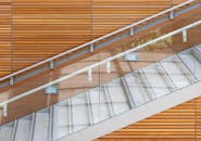 当代楼梯采用玻璃栏杆和木制镶板，突出现代建筑风格