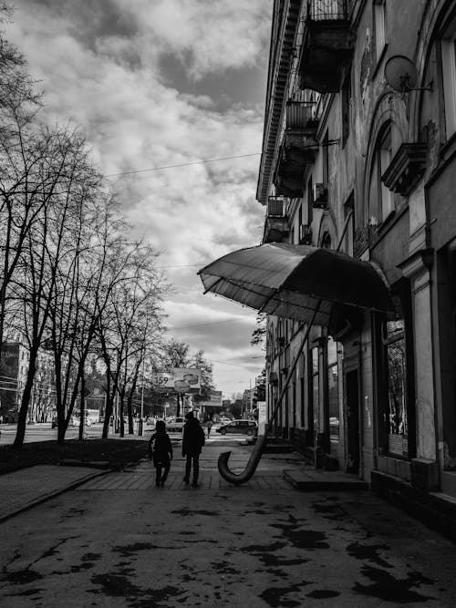 People Walking on Sidewalk Beside a Building