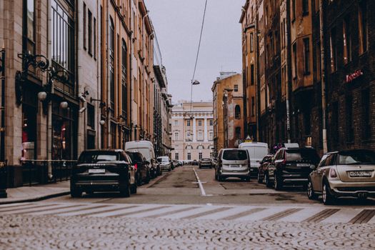 Scenic view of a narrow city street with parked cars lined by historic architecture, ideal for urban themes.