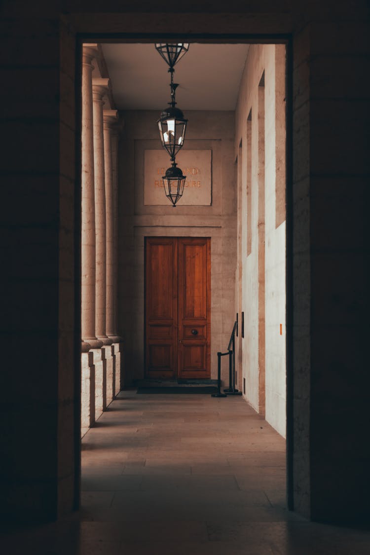 A Hallway With Hanging Bulbs Near Wooden Door