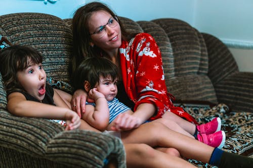 Woman in Red and White Bathrobe Sitting on Couch with Her Children