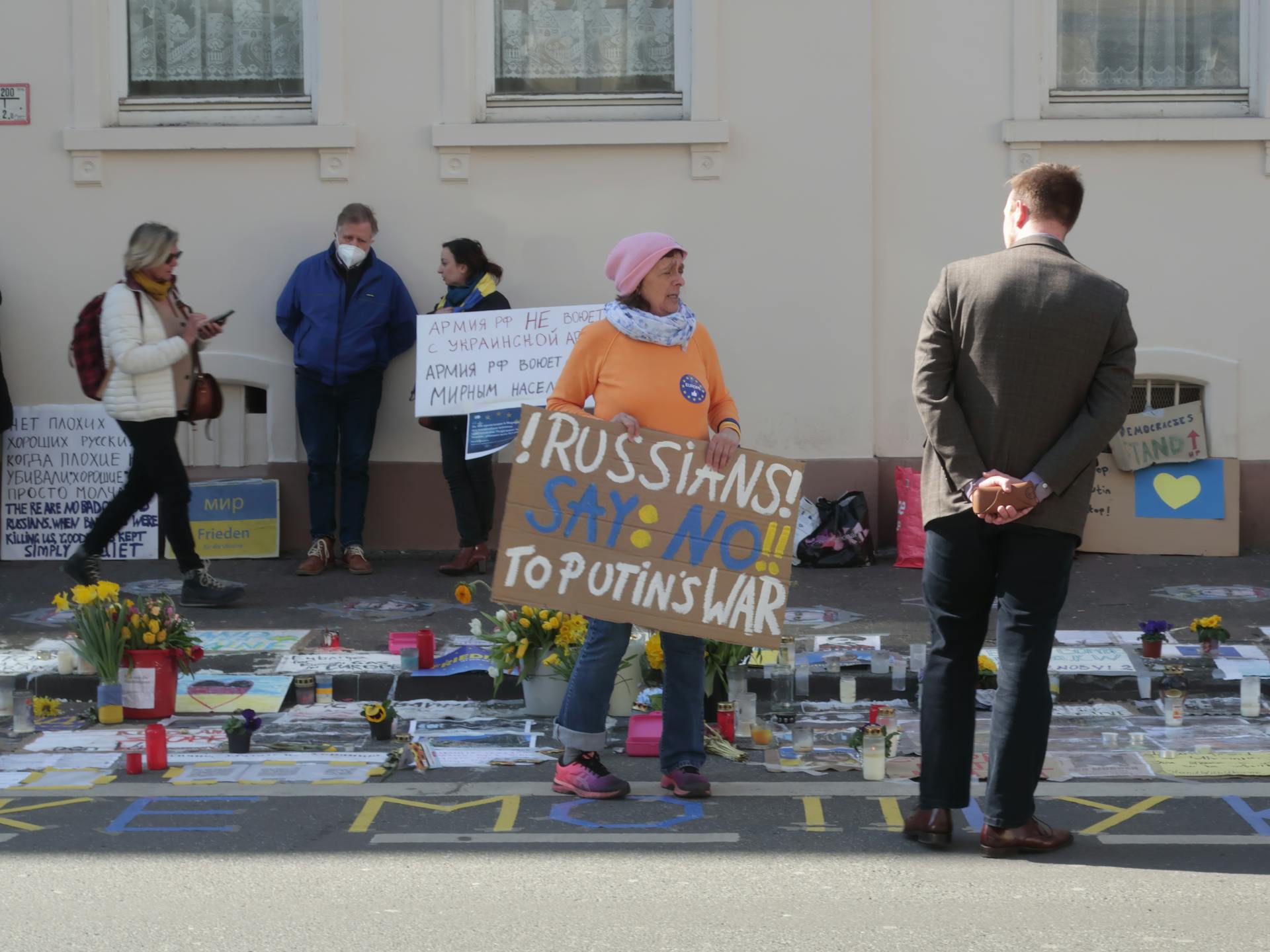 A peaceful protest in Frankfurt with people holding signs against war, highlighting anti-war sentiments.